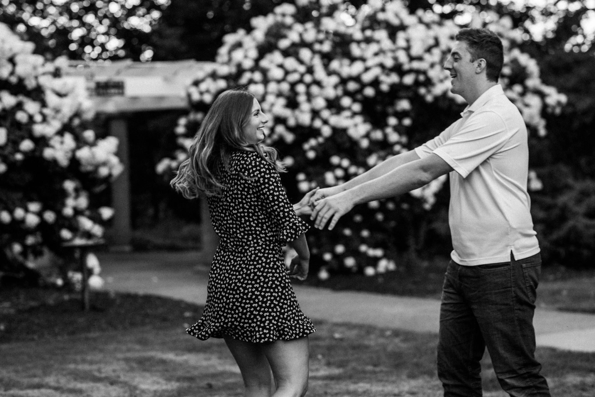 Black and white couple portrait dancing in a rose garden.