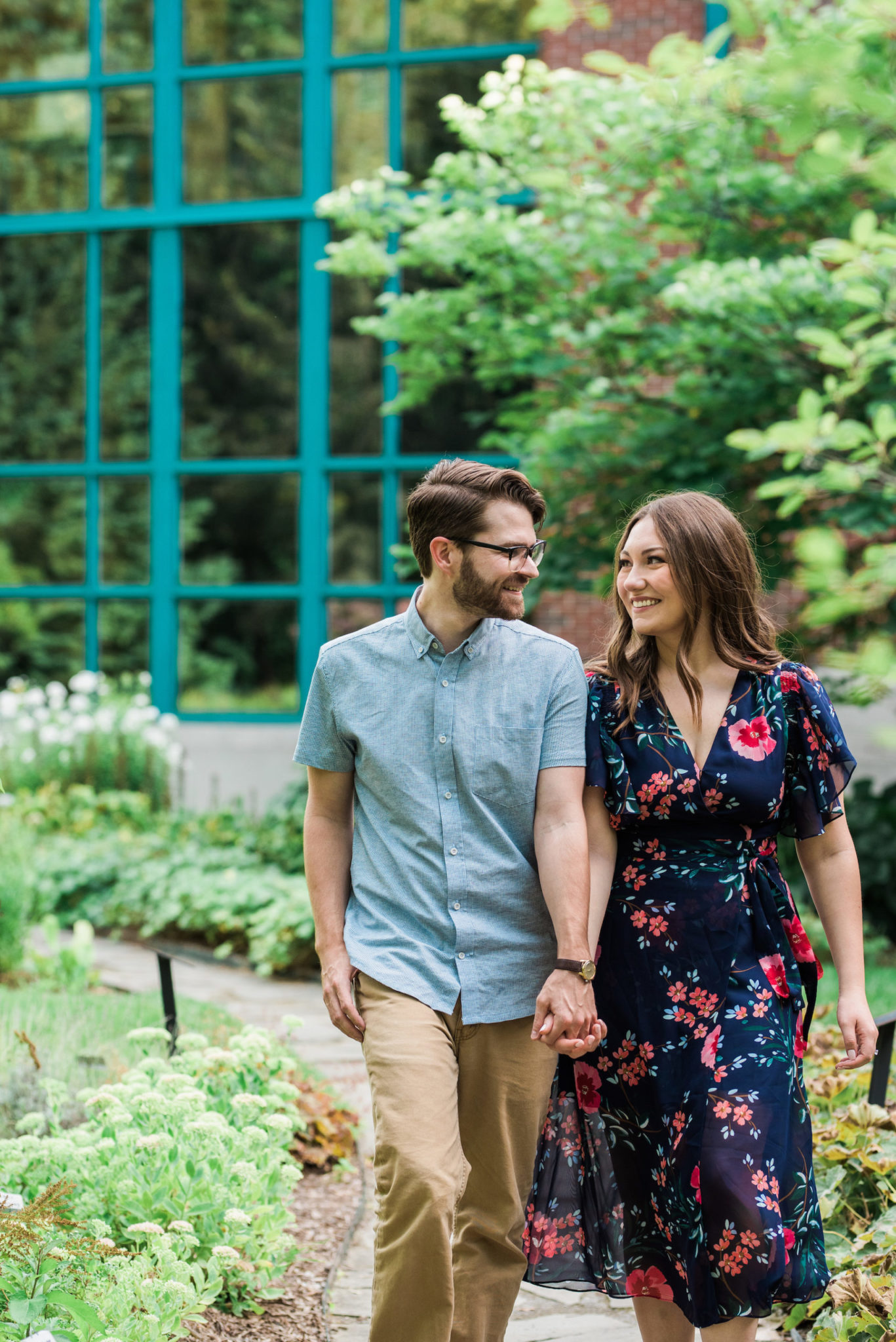Two people walking and smiling in a vibrant summer garden.