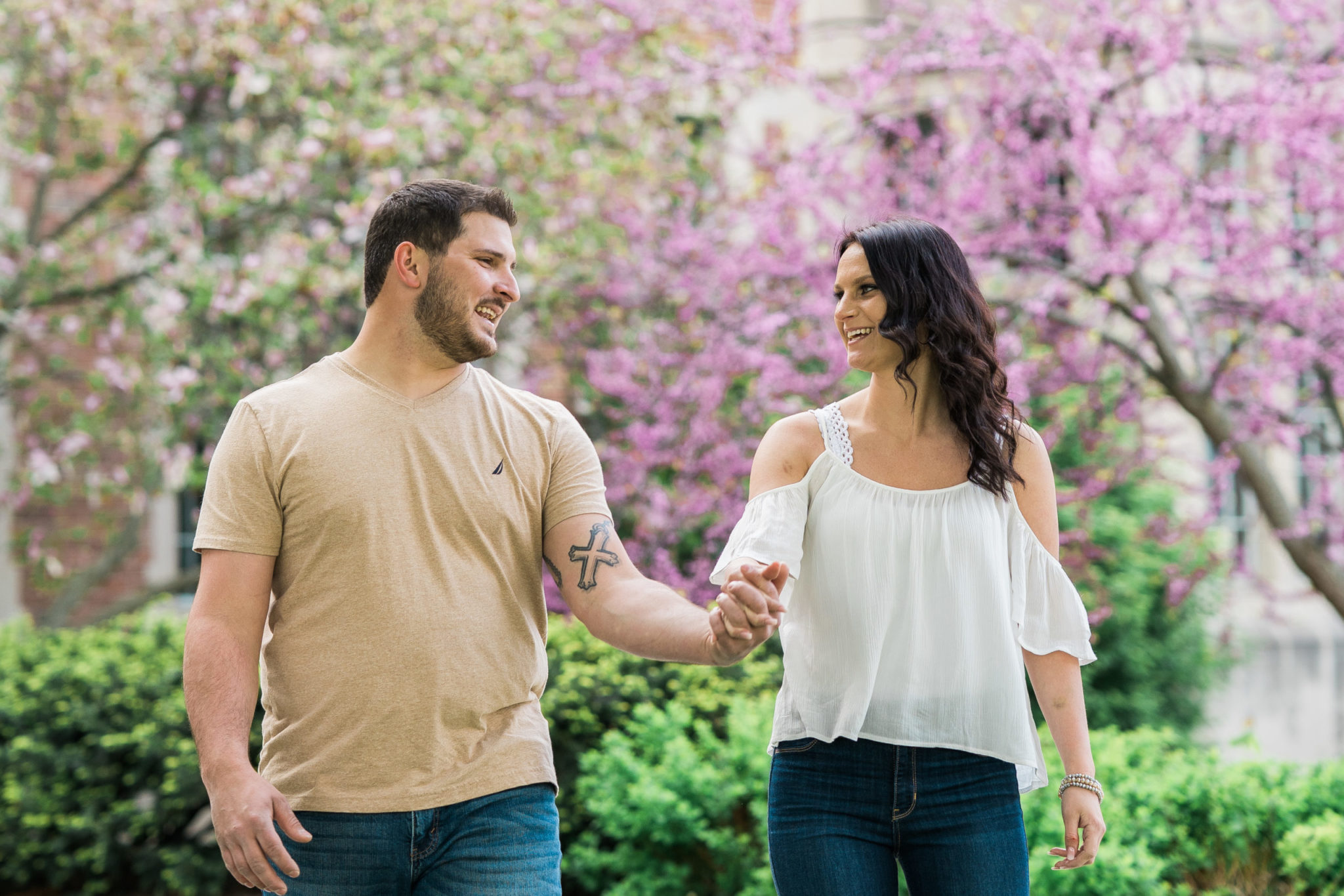 a couple laughing and smiling during their engagement photo session in east lansing