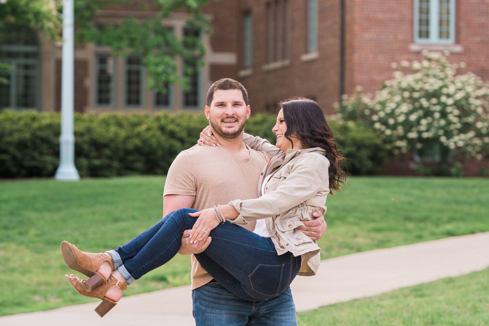 a guy holding a girl during an engagement photo session in east lansing