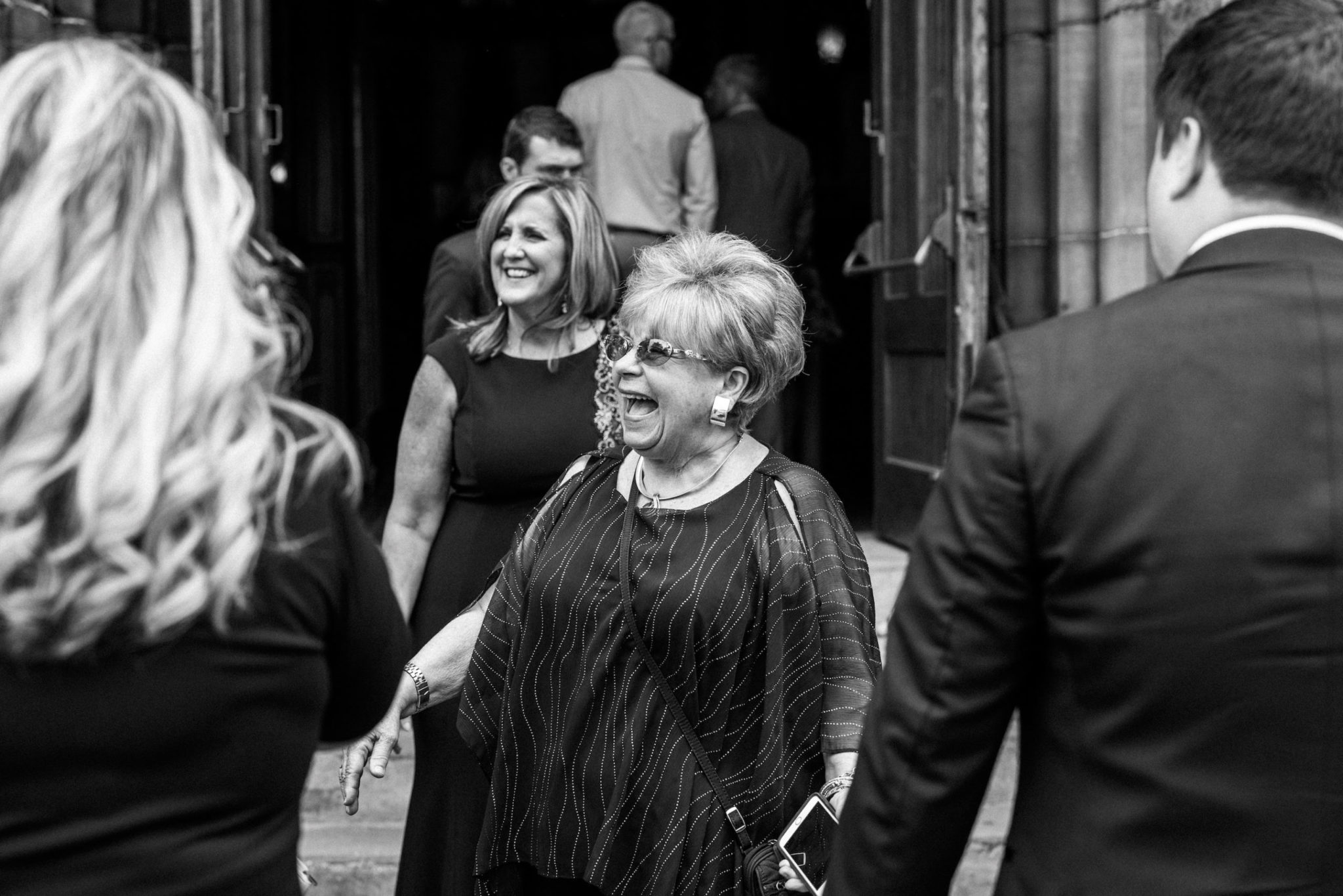 a wedding guest smiling in front of the basilica of sainte anne de detroit church