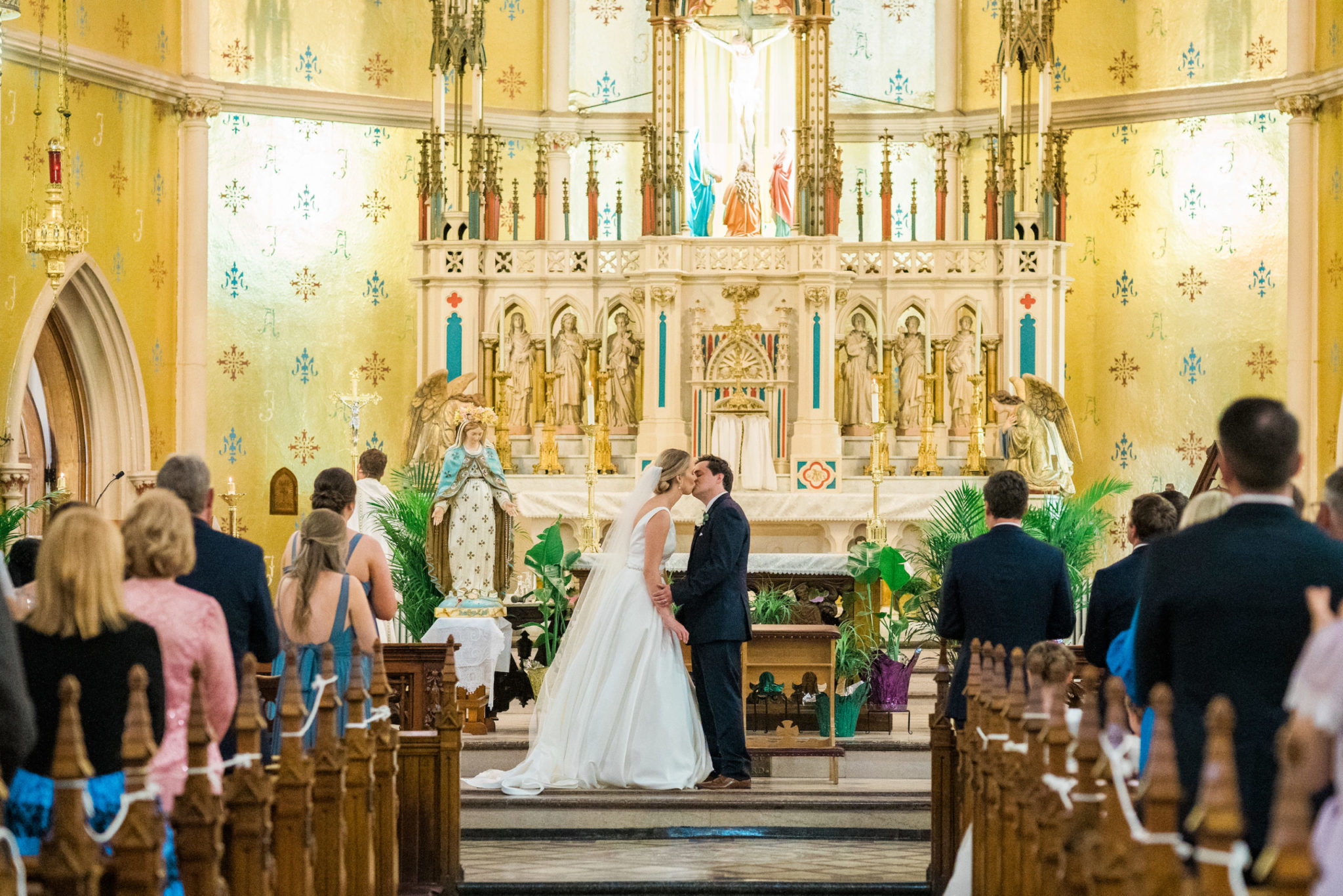 a bride and groom kissing during their wedding ceremony at the basilica of sainte anne de detroit,downtown detroit wedding day