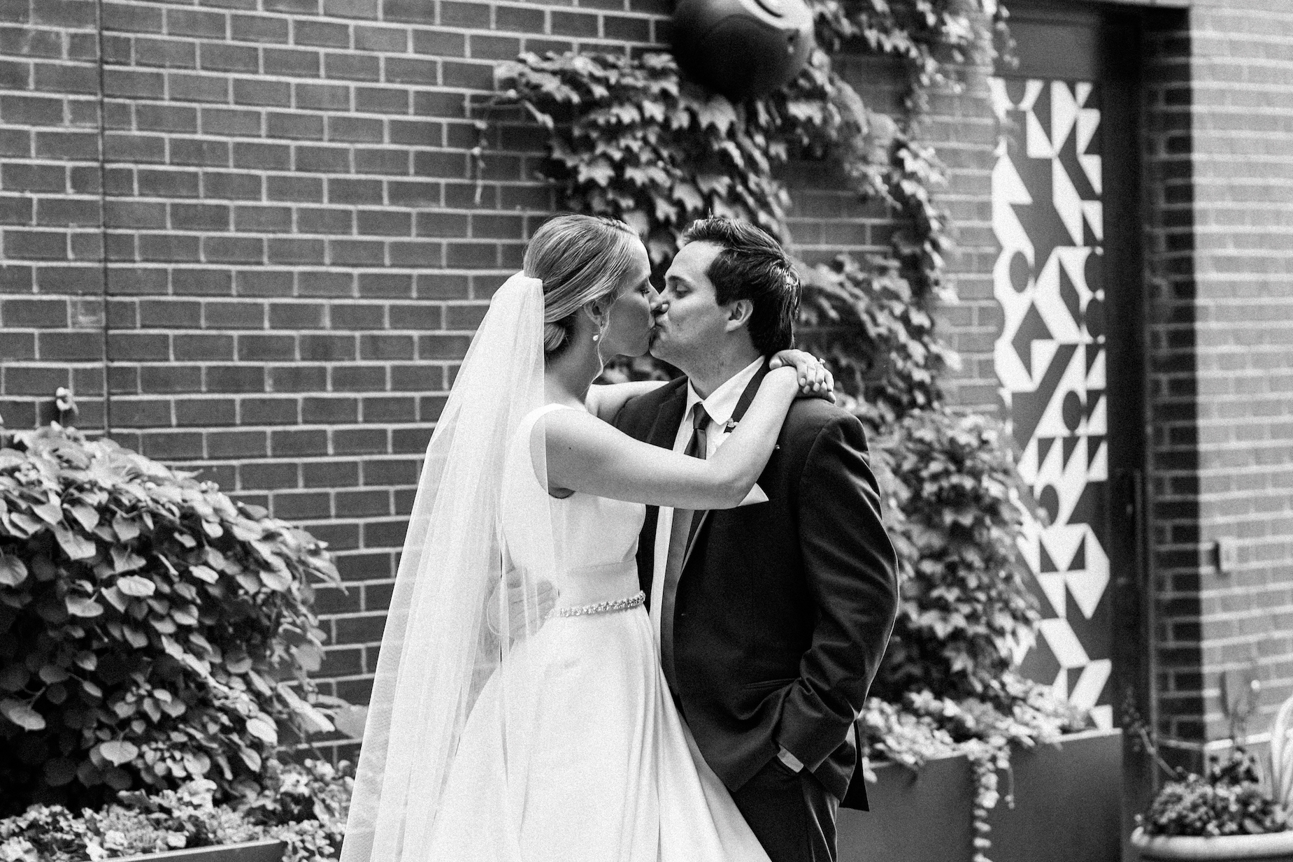 a bride and groom holding and kissing during their wedding day portraits downtown detroit