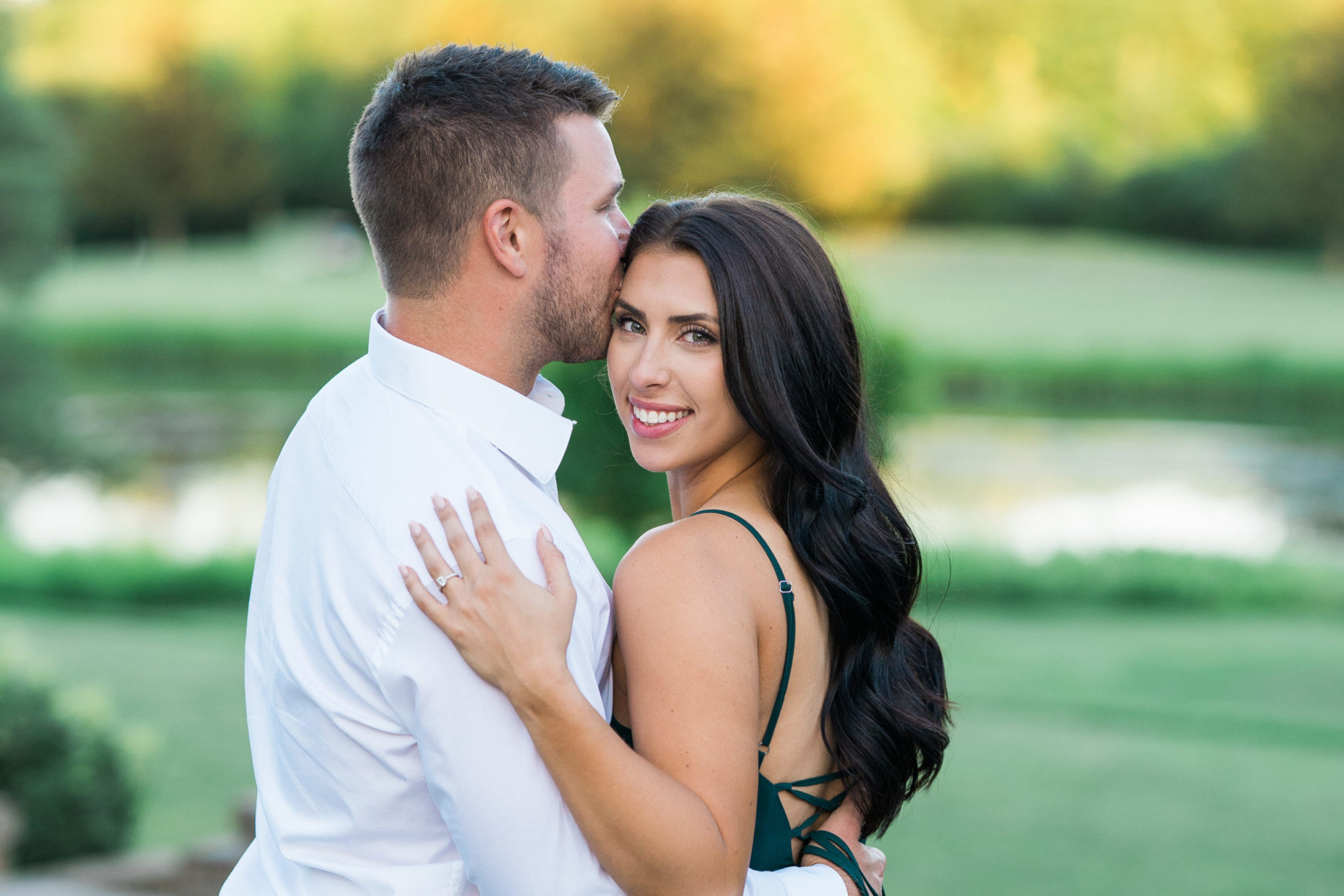 a couple embracing and smiling during their golden hour engagement photo session