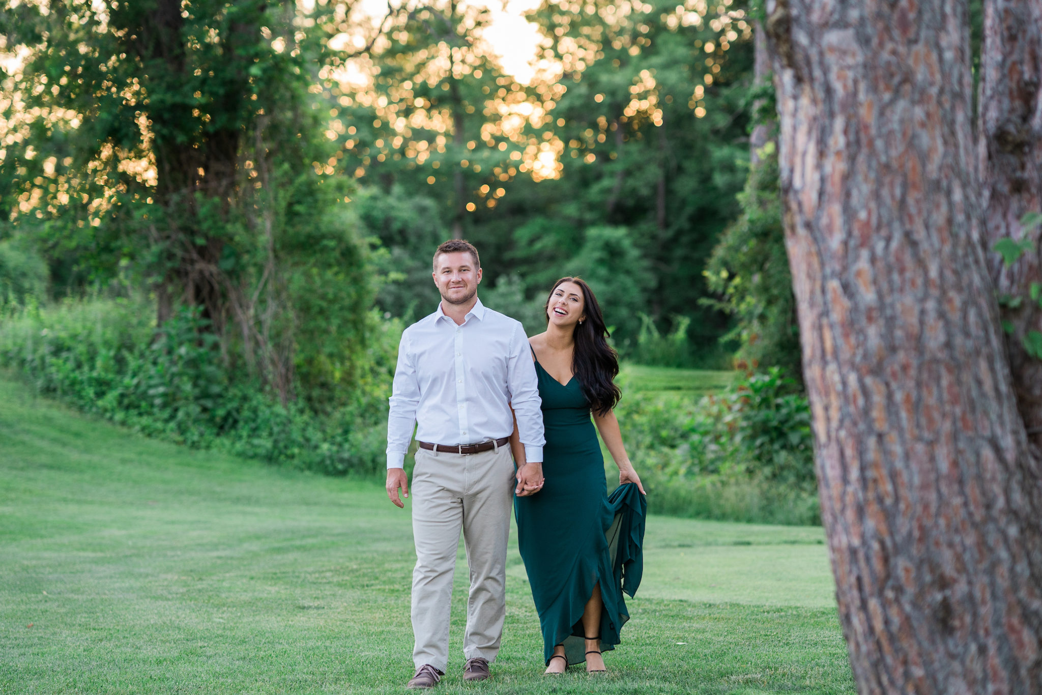 a couple walking and laughing during their golden hour engagement photo session at stoney creek metro park 