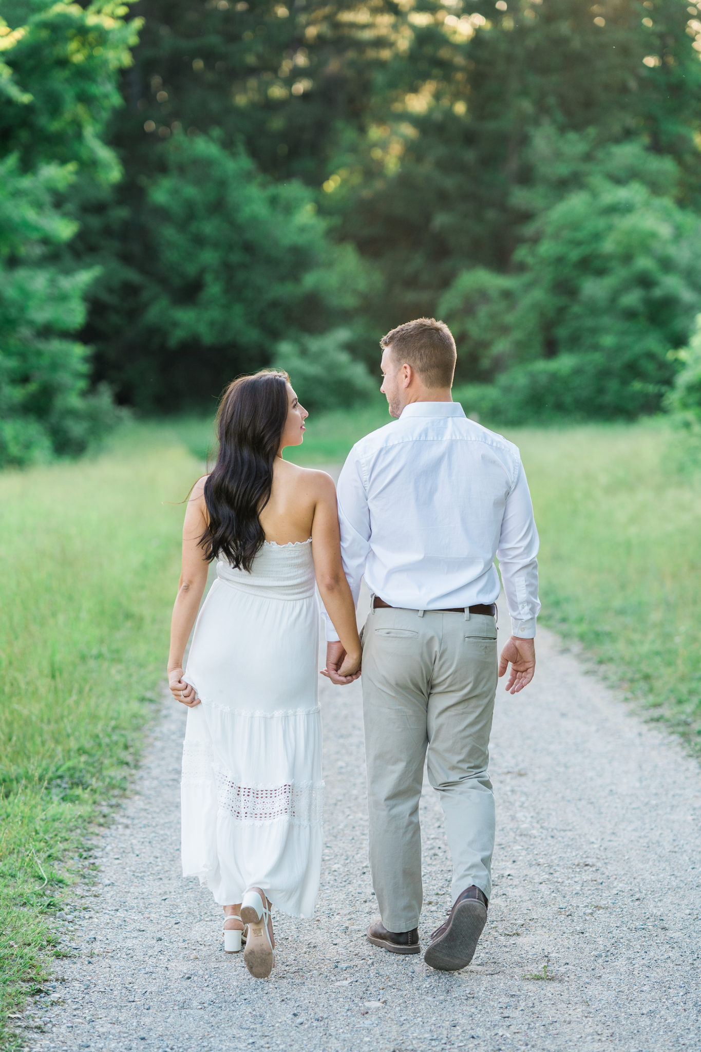 a couple walking on a path at stoney creek metro park during their golden hour engagement photo session