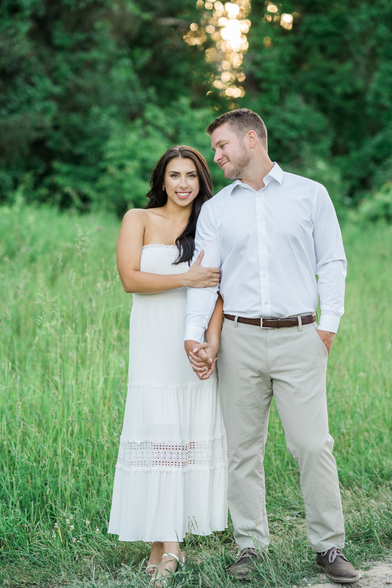 a couple embracing during their golden hour engagement photo session and looking at the camera