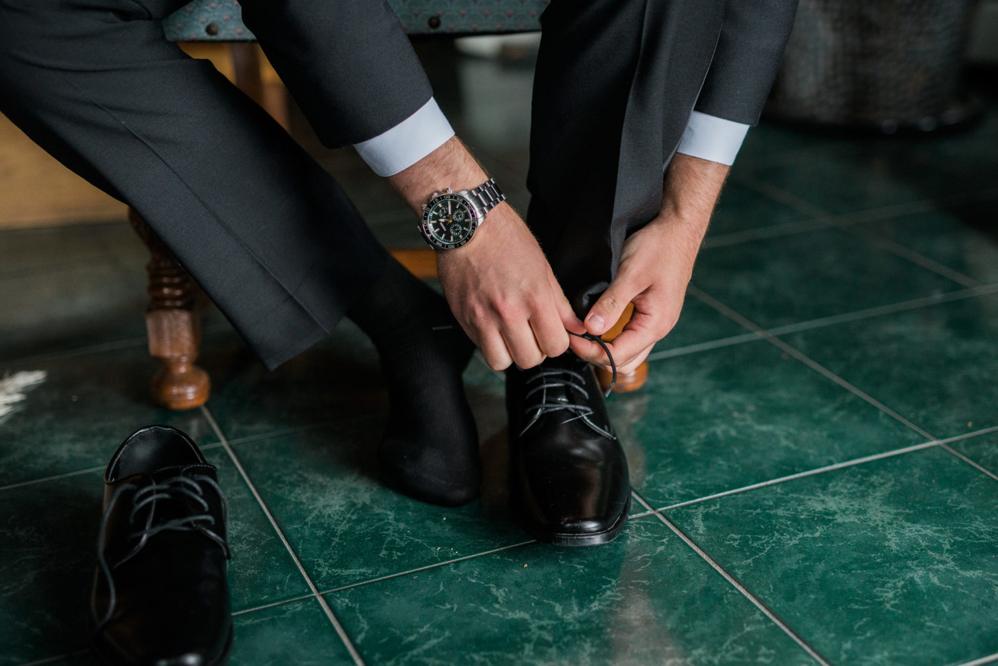 a groom tying his shoes on wedding day