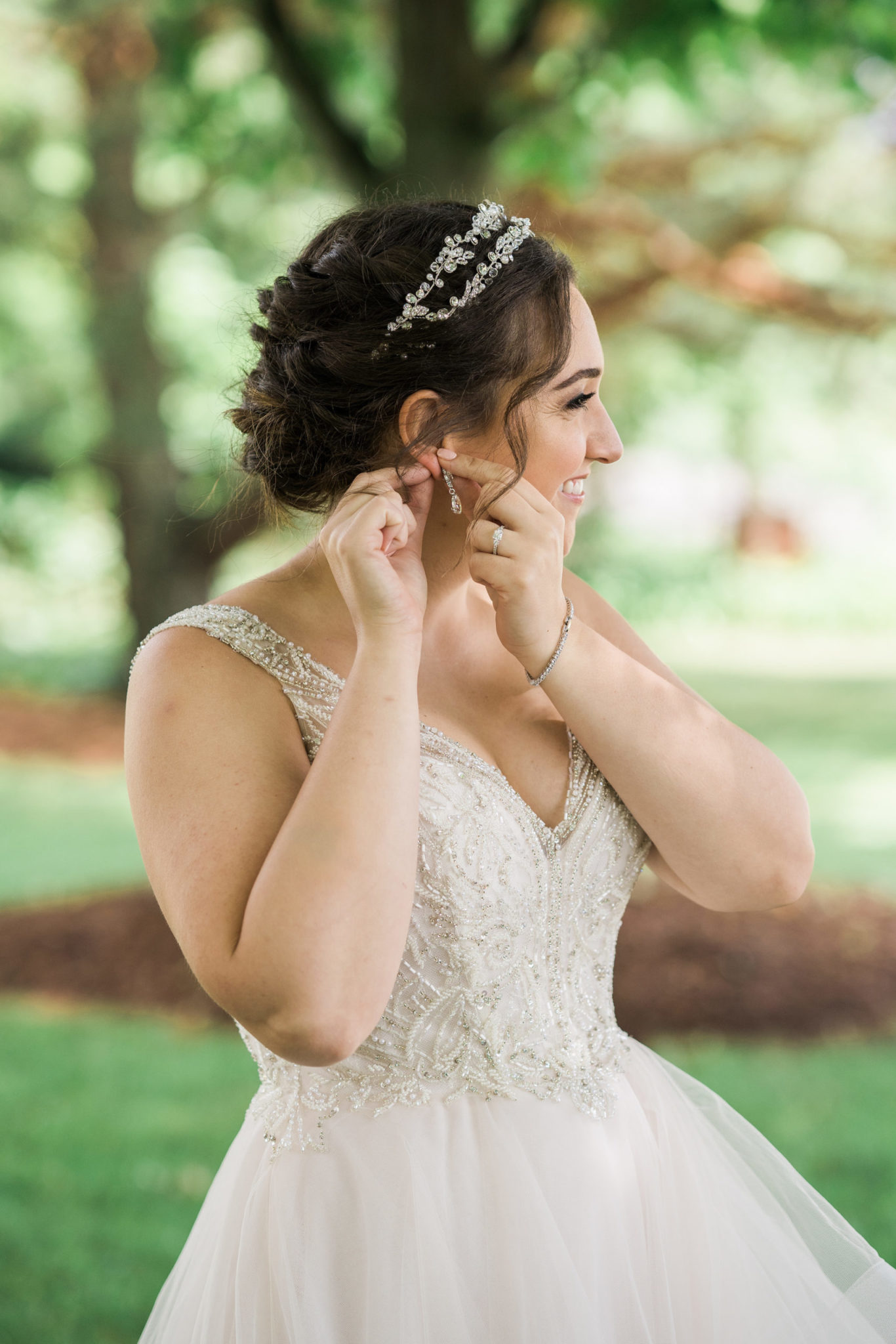 a bride putting in her earrings on her summer wedding day