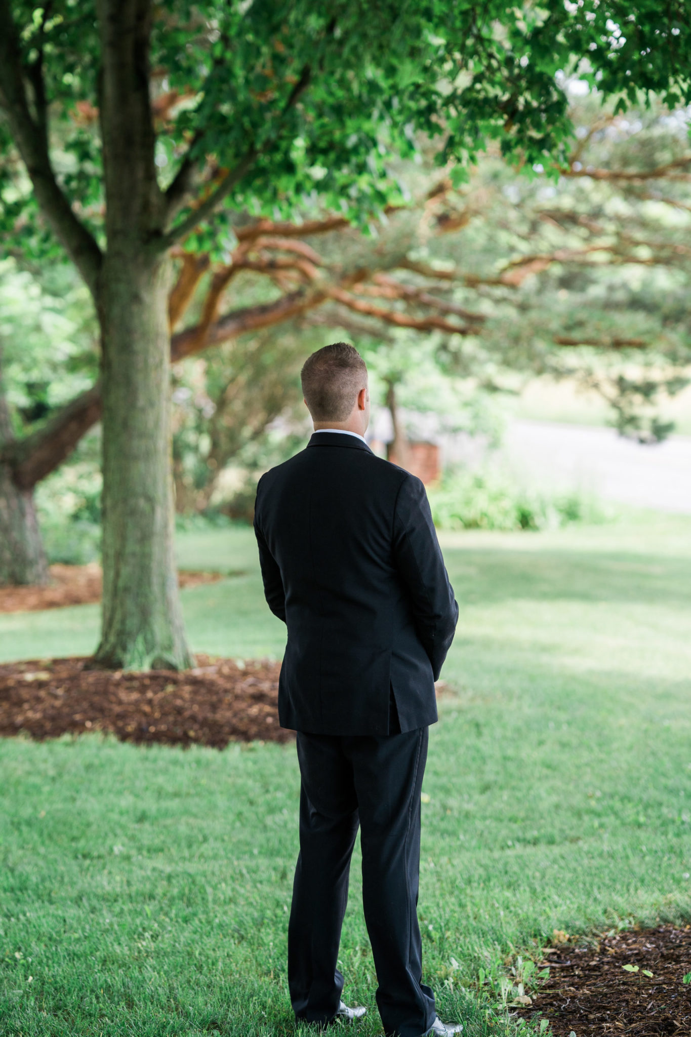 groom waiting for his first look on a summer wedding day
