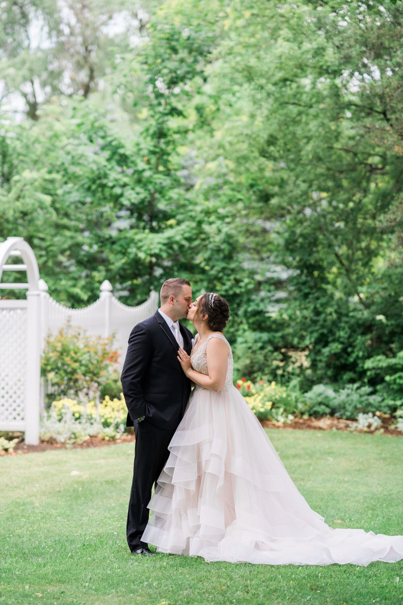 a bride and groom kissing and embracing on their summer wedding day