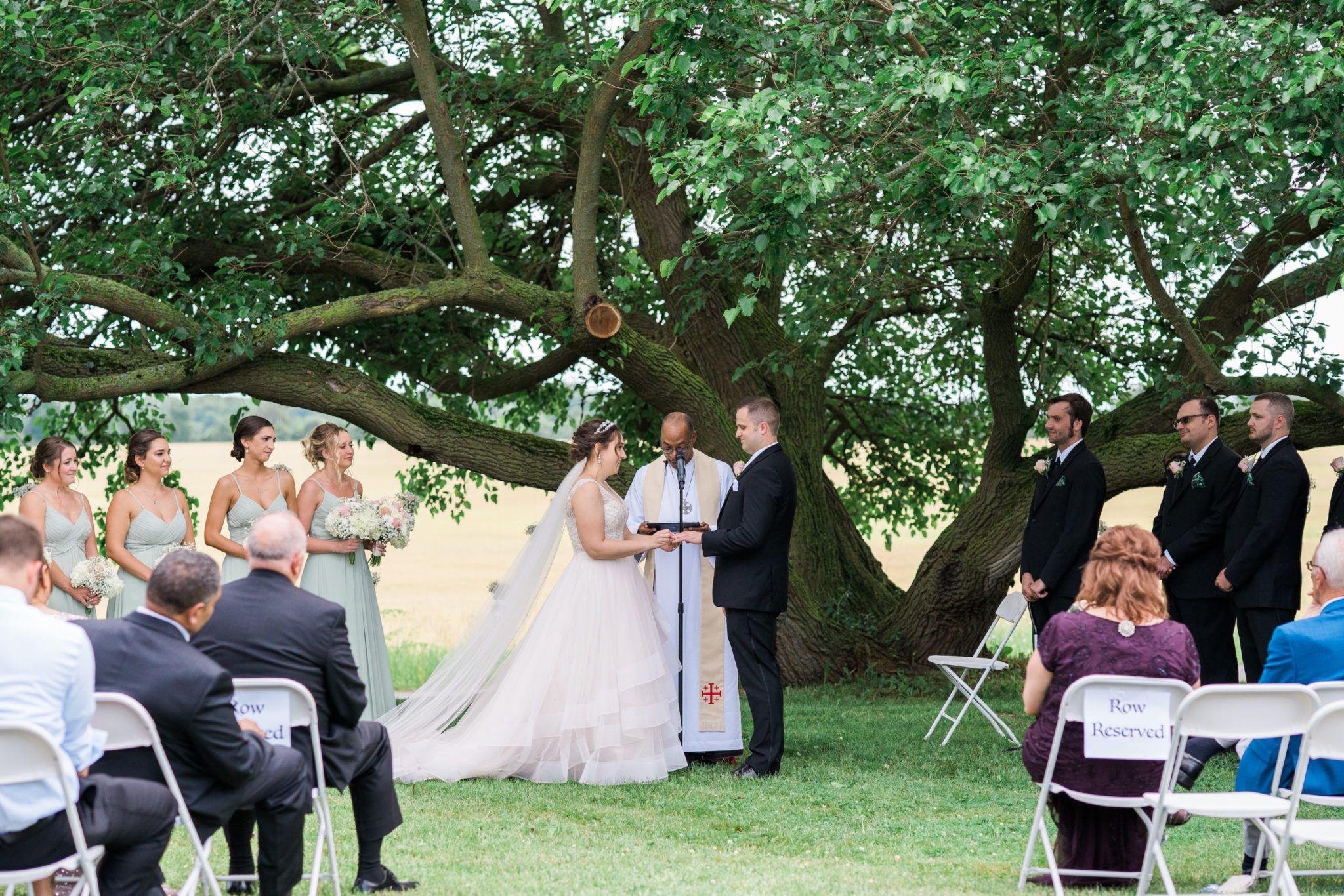 a bride and groom saying vows during their summer wedding ceremony