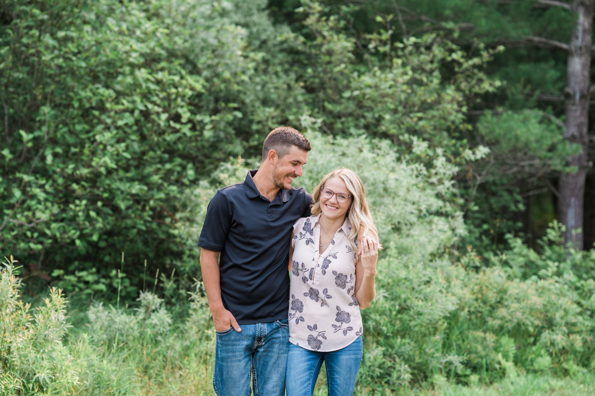 a couple walking and smiling during their engagement session in northern michigan