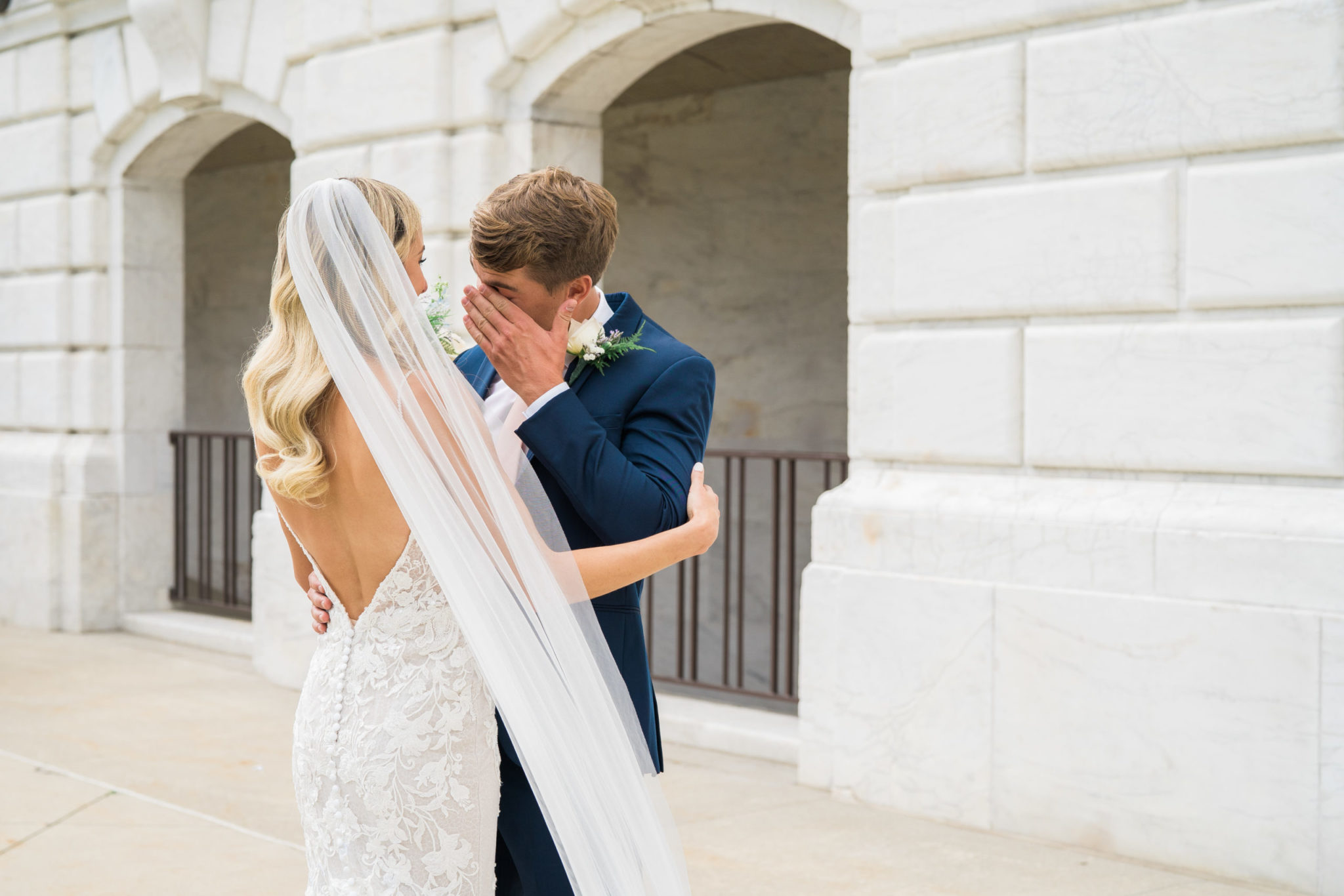 bride and groom holding each other and wiping a tear during their first look at the DIA in detroit michigan