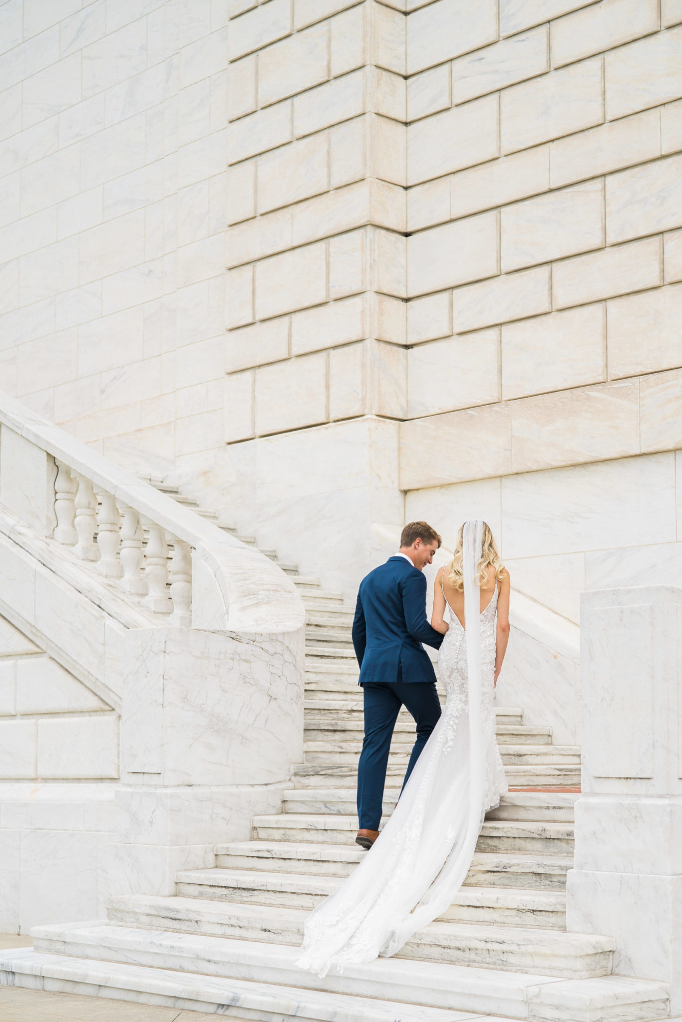 a bride and groom walking up the stairs at the DIA